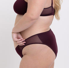 Load image into Gallery viewer, Size 2XL model showing side view of Organic Cotton Black Cherry Mid Rise Brief with mesh sides and non-toxic lace detail