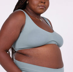 Load image into Gallery viewer, Size 2xl Woman showing side view of sage organic cotton scoop bralette with lace detail and no wire