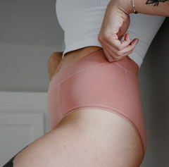 Load image into Gallery viewer, Woman pulling up la coochie organic cotton high rise underwear in high waisted brief style, wearing desert rose pink underwear