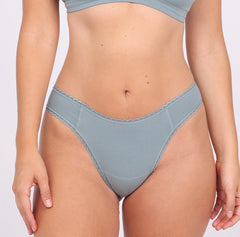Load image into Gallery viewer, Size M model showing front view of sage mid rise thong in certified organic cotton fabric
Sexy high cut leg, non-toxic lace trim, breathable cotton fabric