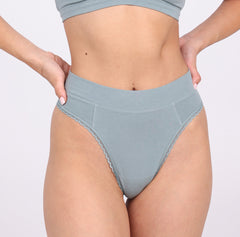 Load image into Gallery viewer, Size X-Small woman showing front view of organic cotton high rise thong in sage color
High waisted fit, breathable cotton fabric, longer gusset, non-toxic lace trim