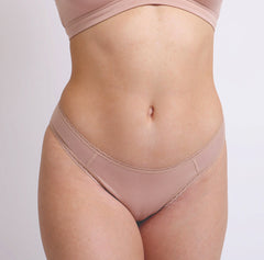 Load image into Gallery viewer, Size S Model wearing Organic Cotton champagne nude Mid Rise Brief with no toxic lace detail