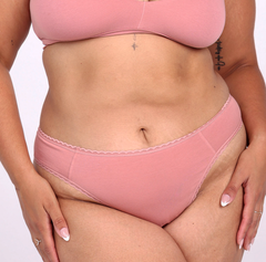 Load image into Gallery viewer, Size L model showing front view of desert rose mid rise thong in organic cotton fabric
Sexy high cut leg, non-toxic lace trim, breathable cotton fabric