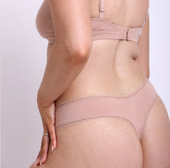 Load image into Gallery viewer, Size M model showing front view of champagne nude mid rise thong in organic cotton fabric
Sexy high cut leg, non-toxic lace trim, breathable cotton fabric