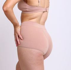 Load image into Gallery viewer, Size small woman showing back view of organic cotton boyshort in champagne color with full coverage
