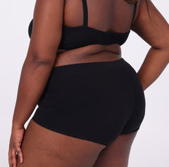 Load image into Gallery viewer, Size 2xl woman showing back view of certified organic cotton boyshort in midnight black full coverage