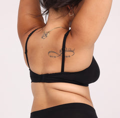 Load image into Gallery viewer, Size medium Woman showing back view of black soft certified organic cotton scoop bralette with lace details