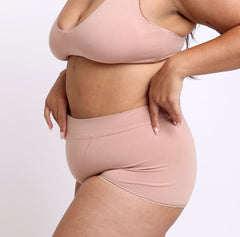 Load image into Gallery viewer, Size large woman showing waistband and side view of certified organic cotton boyshort in champagne color
No side seams, full coverage, longer gusset, super soft cotton fabric
