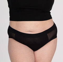 Load image into Gallery viewer, Front view of XXL woman wearing organic cotton high rise brief underwear in black featuring mesh panels
