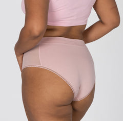 Load image into Gallery viewer, Side and back view of woman wearing high rise organic cotton brief underwear in blush pink featuring lace detail and soft waistband
