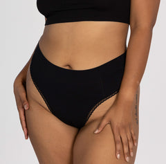 Load image into Gallery viewer, Woman wearing all organic cotton fabric high rise thong underwear style in midnight black
