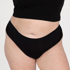 Load image into Gallery viewer, Front view of XXL woman wearing la coochie organic cotton thong underwear with high waist high rise waistband in midnight black