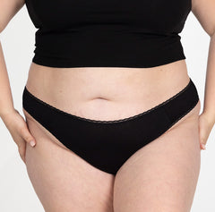 Load image into Gallery viewer, XXL woman front view wearing la coochie organic cotton mid rise underwear in brief style, midnight black color and featuring lace detail close up

