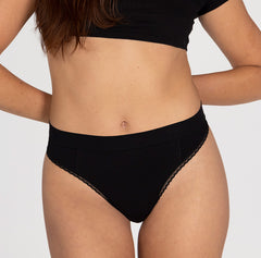 Load image into Gallery viewer, Front view of woman wearing midnight black all organic cotton black high rise thong with sexy lace details