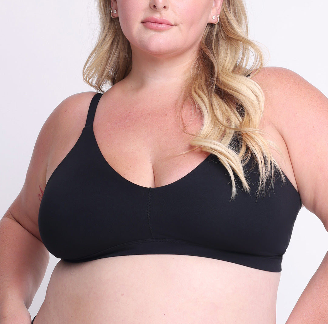 Size 2XL model showing front view of organic cotton triangle bralette in midnight black. Wireless, fully lined cups with adjustable multi-way straps
