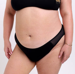 Load image into Gallery viewer, Size 2XL model showing off front and side of Organic Cotton Black Mid Rise Brief with mesh sides and non-toxic lace detail
