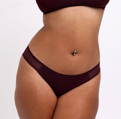 Load image into Gallery viewer, Size M Model wearing Certified Organic Cotton Black Cherry Mid Rise Brief with mesh sides and non-toxic lace detail
