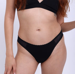 Load image into Gallery viewer, Size XS  Model wearing Organic Cotton Black Mid Rise Brief with mesh sides and non-toxic lace detail
