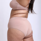 Back profile image of a large model wearing a high rise brief made from certified organic cotton
lightweight breathable material, smooth side-seam-free design, and cheeky back coverage.