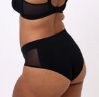 Size L model showing back view of black high rise brief in certified organic cotton fabric 
No side seams, elastic-free waistband, non-toxic lace trim, cheeky coverage