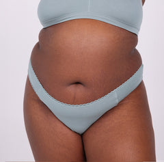 Load image into Gallery viewer, Size 3XL model showing front view of sage mid rise thong in organic cotton fabric 
Sexy high cut leg, non-toxic lace trim, breathable cotton fabric
