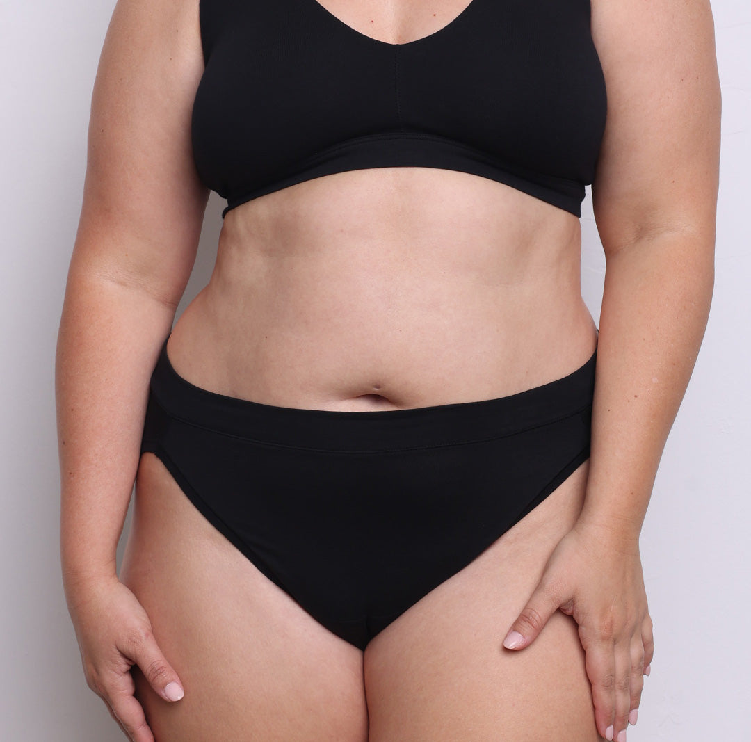 Size L model showing front view of organic cotton French-cut high brief in midnight black. Breathable, super soft organic cotton with a high French-cut leg