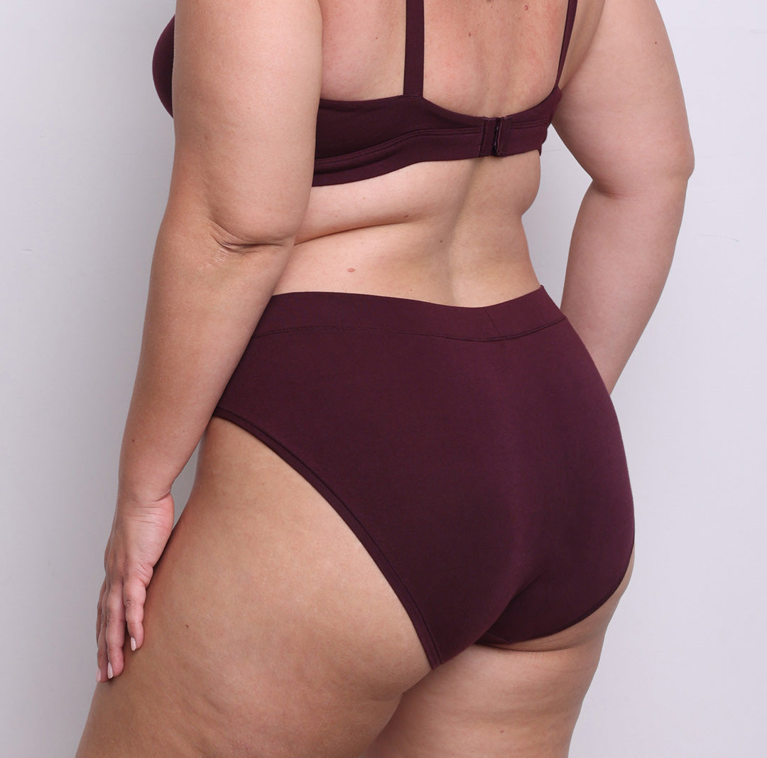 Size L model showing back view of organic cotton French-cut high brief in black cherry. Breathable, super soft organic cotton with a high French-cut leg