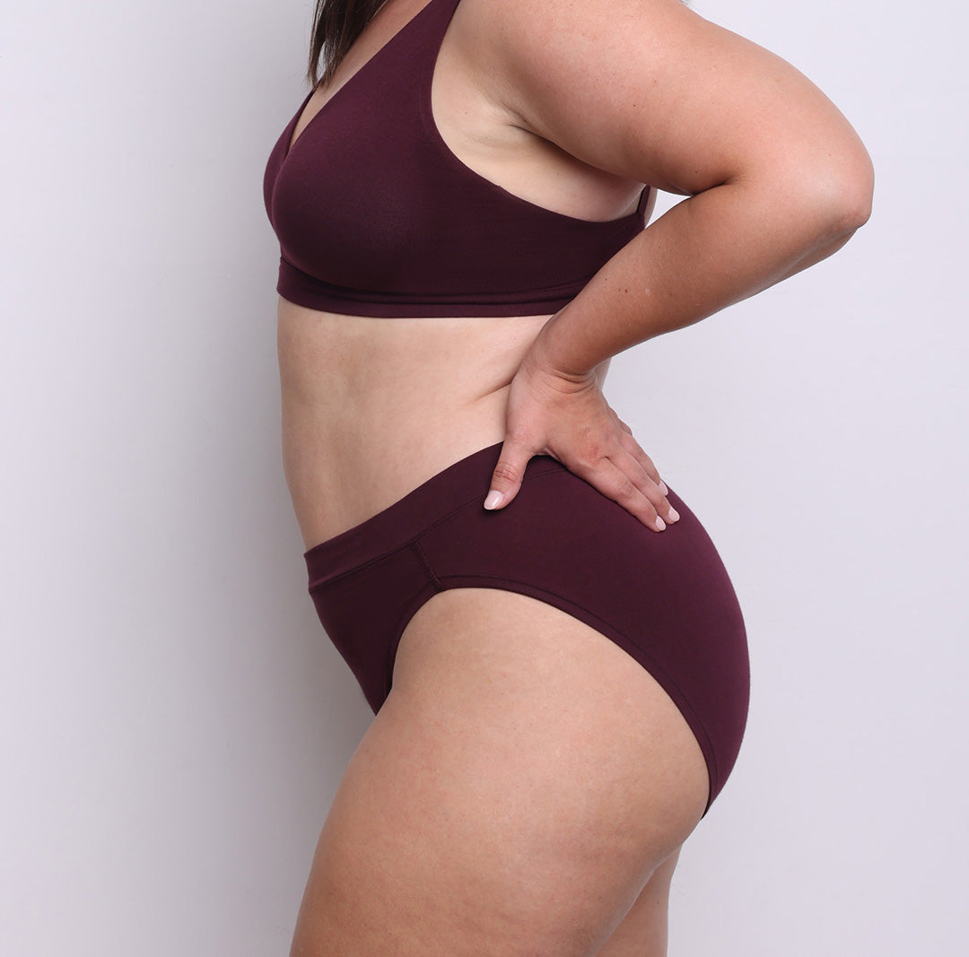 Size L model showing side view of organic cotton French-cut high brief in black cherry. Breathable, super soft organic cotton with a high French-cut leg