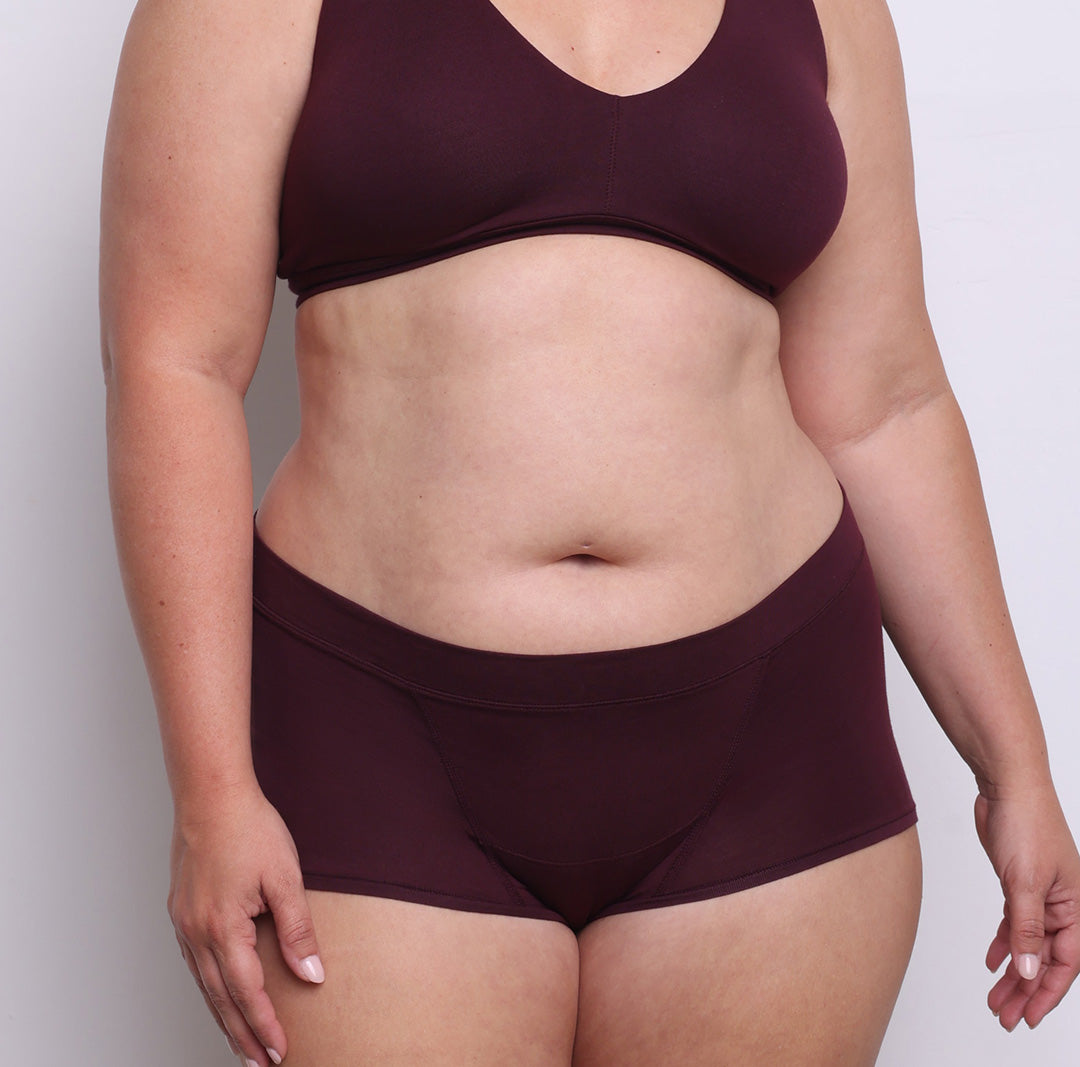 Size L model showing front view of organic cotton mid rise boyshort in black cherry. Soft elastic-free waistband, no front or side seams and full coverage