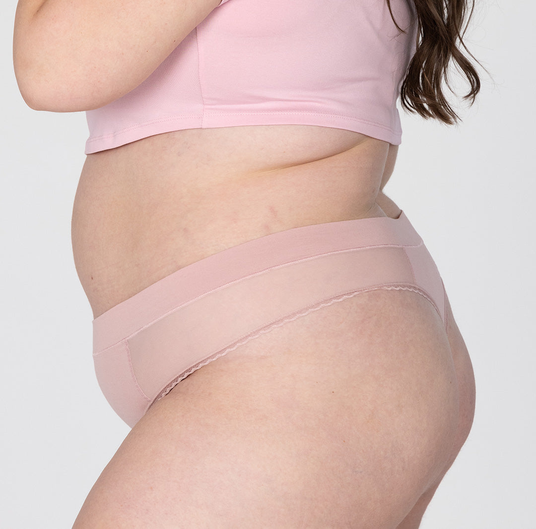 Size 2XL woman showing side view of organic cotton high rise thong in blush pink
High waisted fit, super soft cotton fabric, longer gusset, non-toxic lace trim