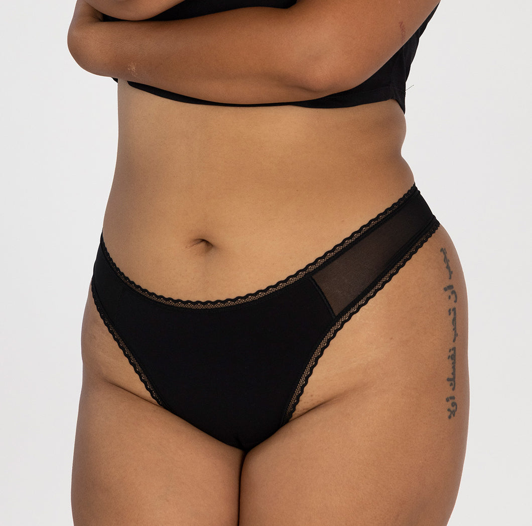 model wearing la coochie organic cotton mid rise thong underwear in midnight black, best mid rise waist thong option