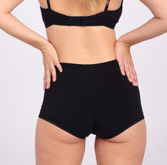 Load image into Gallery viewer, Size M woman showing back view of midnight black certified organic cotton boyshort with full coverage
