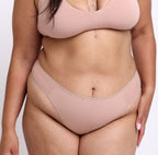 Size L model showing front view of champagne mid rise thong in comfy, breathable organic cotton fabric 
Sexy high cut leg, non-toxic lace trim, lightweight cotton fabric