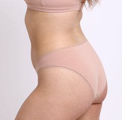 Load image into Gallery viewer, Size M model showing back view of Organic Cotton champagne Mid Rise Brief with cheeky coverage and no side seams
