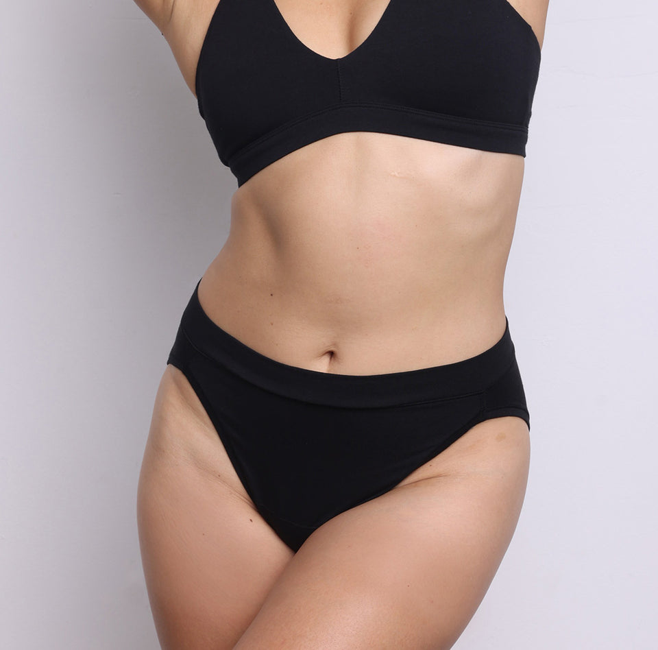 Size S model showing front view of organic cotton French-cut high brief in midnight black. Breathable, super soft organic cotton with a high French-cut leg