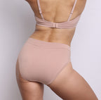 Size S model showing back view of organic cotton French-cut high brief in champagne. Breathable, super soft organic cotton with a high French-cut leg