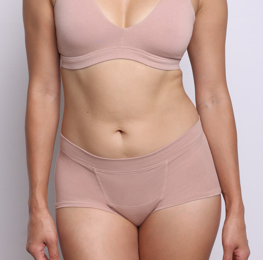 Size S model showing front view of organic cotton mid rise boyshort in champagne. Soft elastic-free waistband, no front or side seams and full coverage