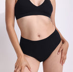 Size XS model showing front view of certified organic cotton high rise brief in midnight black
breathable, super soft cotton fabric with no side seams and cheeky coverage