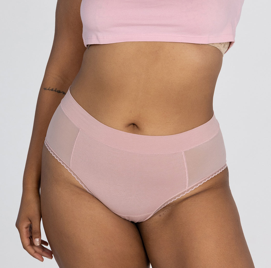 Woman wearing blush pink high rise organic cotton brief style with mesh panels