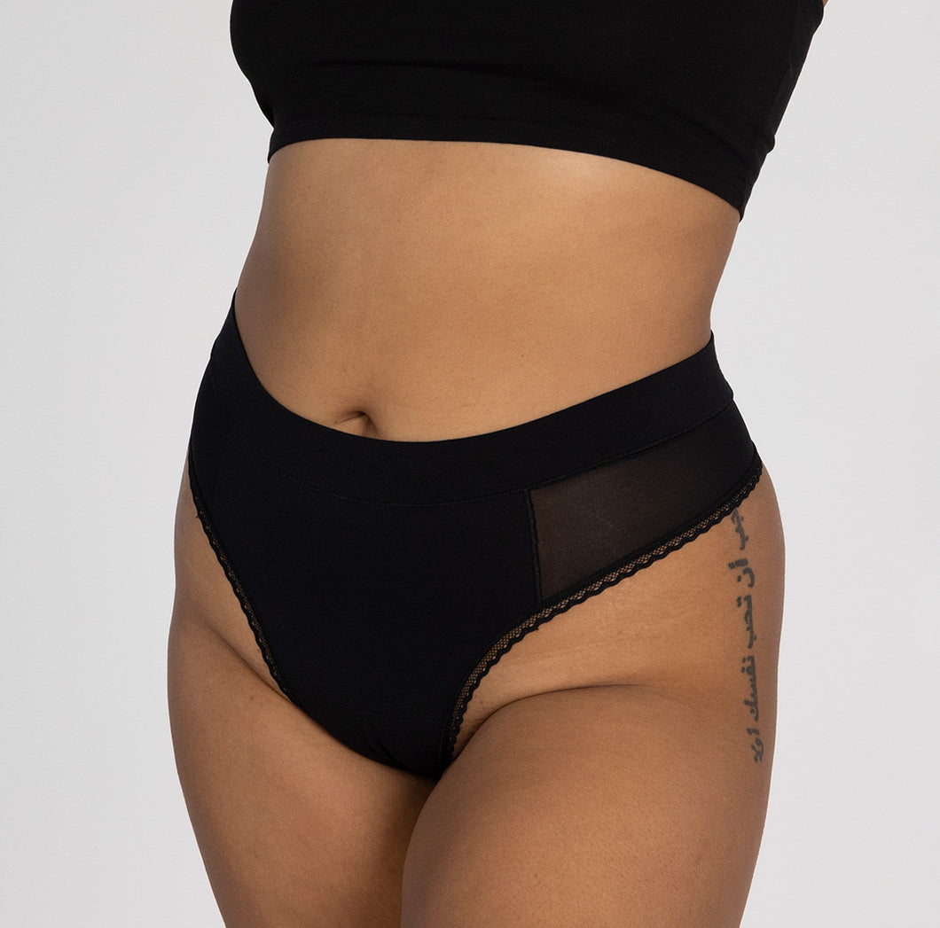 Front view of woman wearing la coochie organic cotton midnight black high rise thong with mesh panels