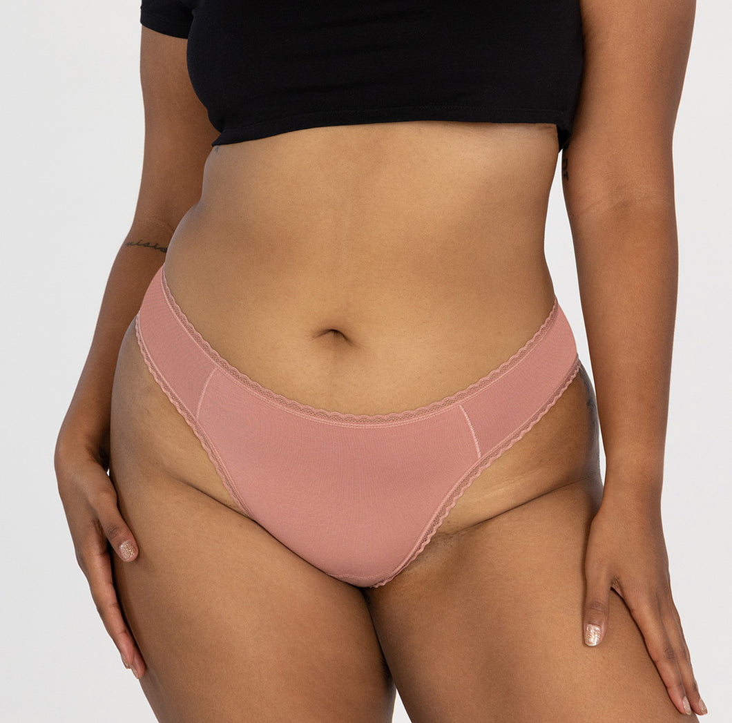 Model wearing organic cotton mid rise underwear in brief style. Wearing desert rose pink color in all-cotton style.