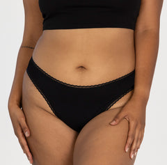 Load image into Gallery viewer, Model wearing best organic cotton underwear mid rise brief in midnight black color, all-cotton style.
